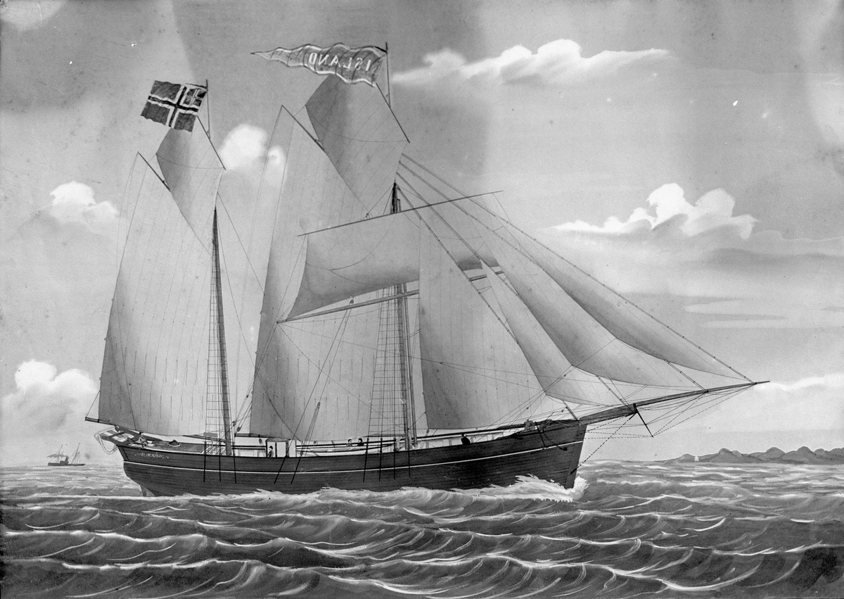 Avfotografert maleri av galeasen "Island" i fin vind. I bakgrunnen seiler et dampskip og man ser en stripe land.
