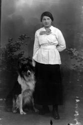 Studioportrett av en kvinne ved siden av en hund.