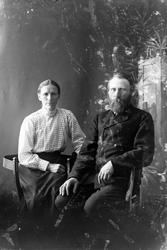 Studioportrett av et eldre par som sitter.