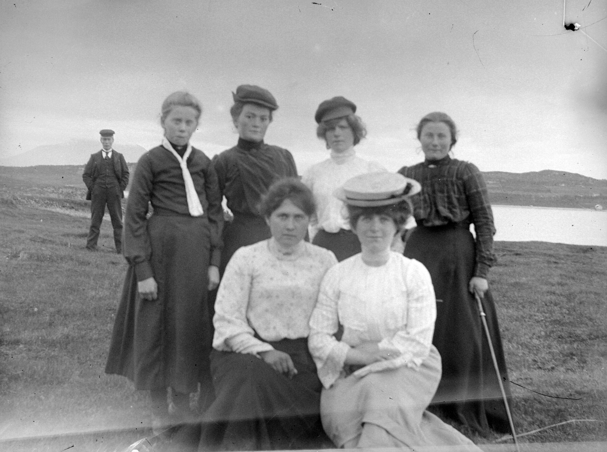 En gruppe kvinner med en mann i bakgrunnen.