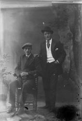 Studioportrett av to menn i helfigur.