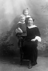 Studioportrett av en kvinne med to barn.