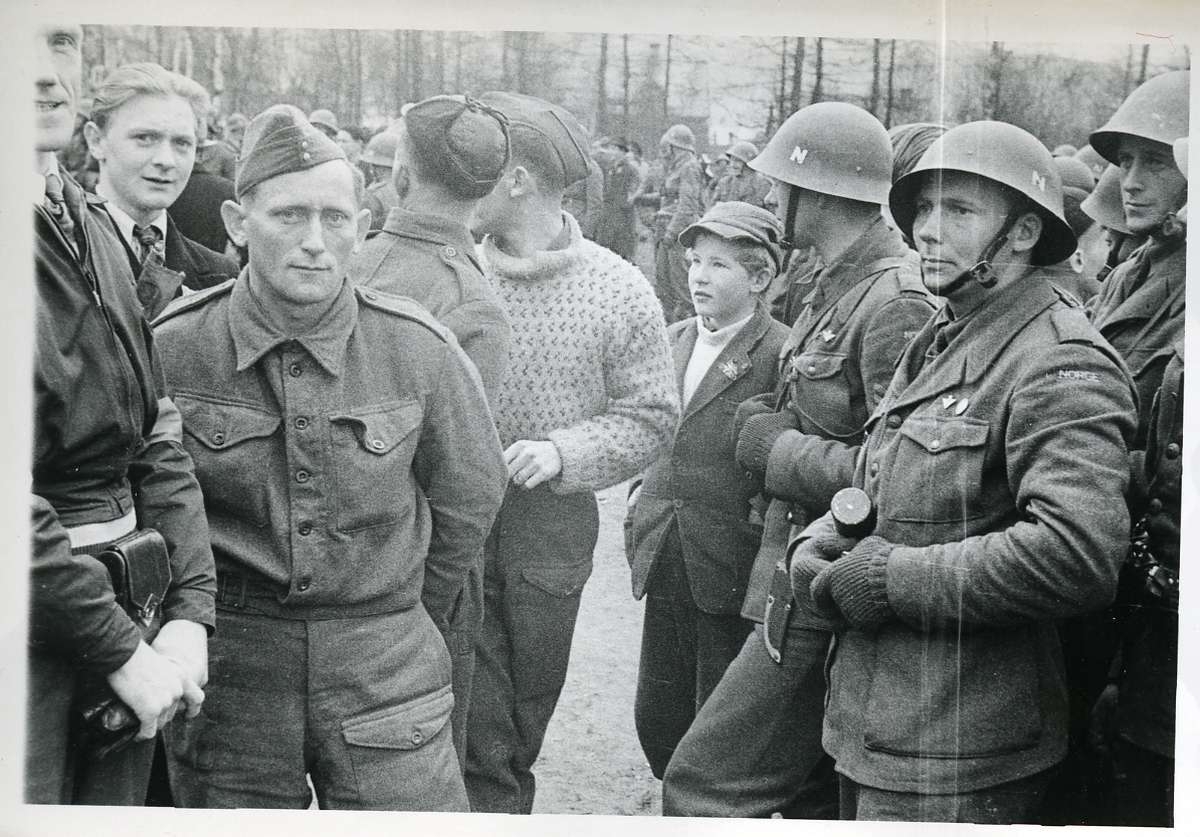 De norske polititroppene tropper ankommer Narvik stasjon. Helt til venstre sees så vidt frisør Ingvald Hope.