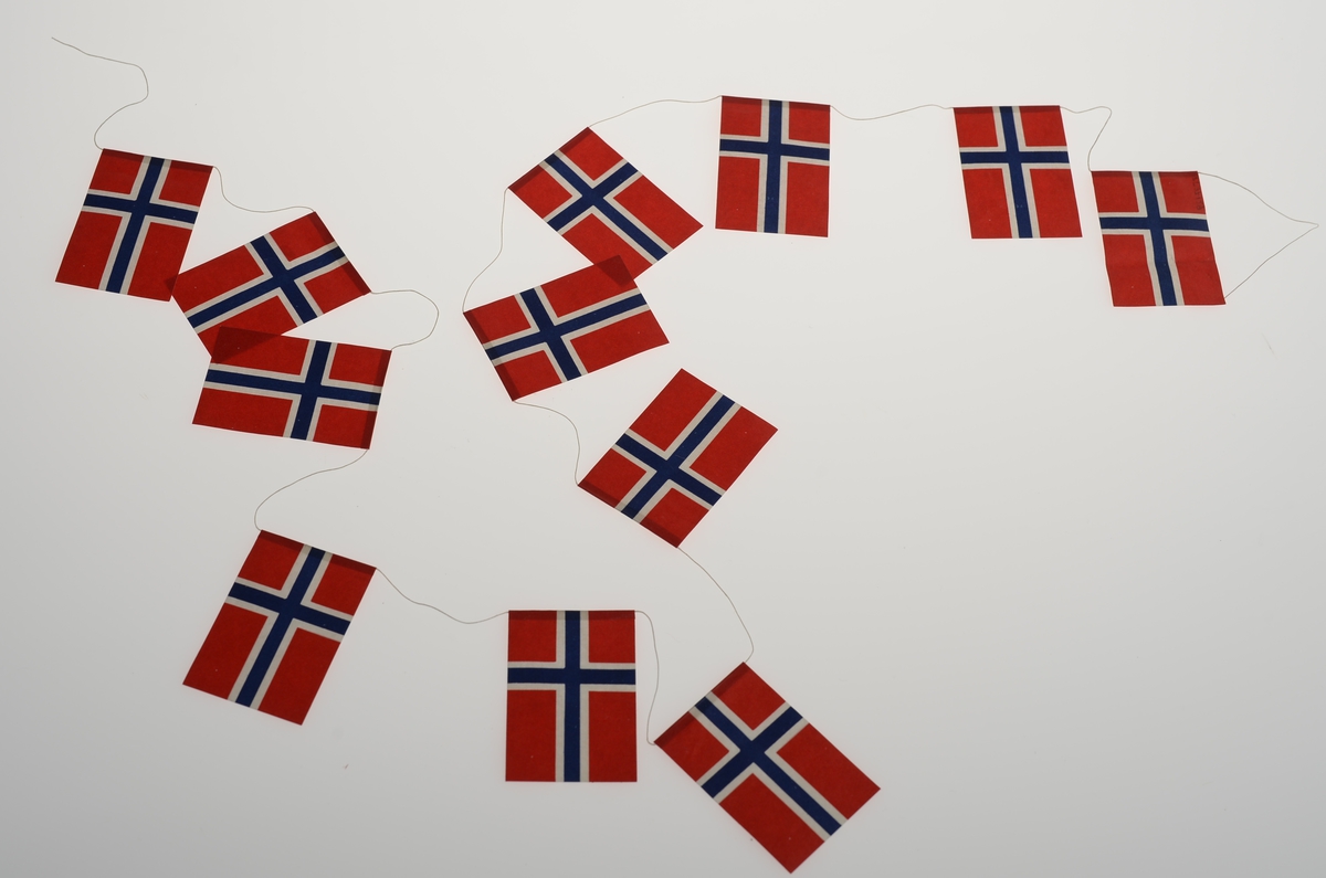 Lenke med 12 stk. norske flagg forbundet med en tynn tråd.