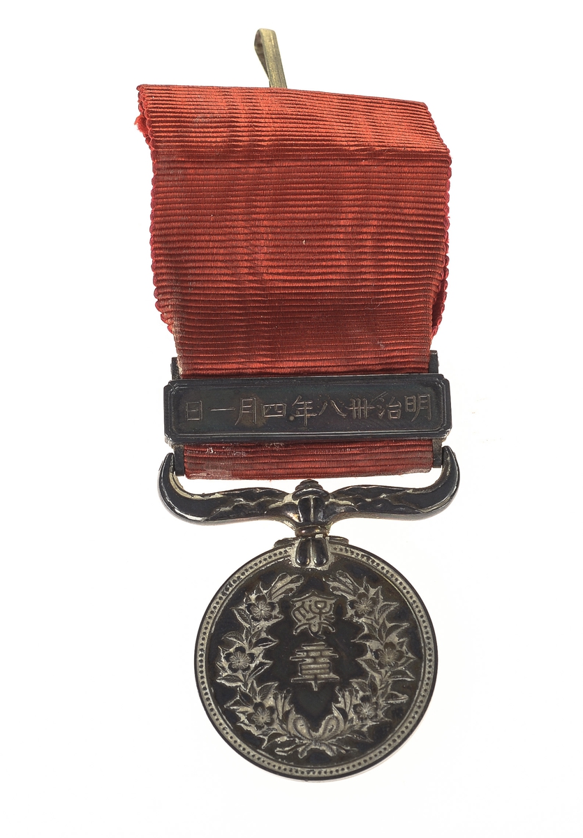 Medalje i etui. Japansk skriftspråk på etui og på medalje.