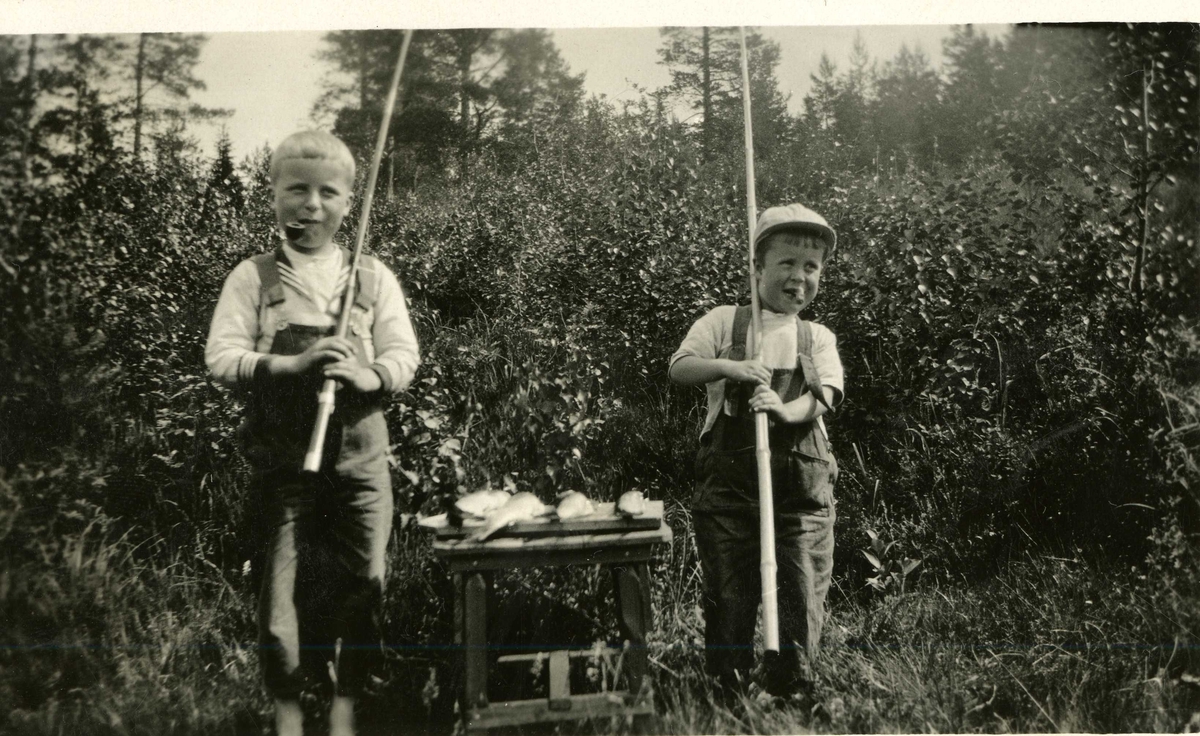 To gutter med fiskestang og fangst. en røyker pipe og en sigar. En gutt er trolig Ragnar Skarre.