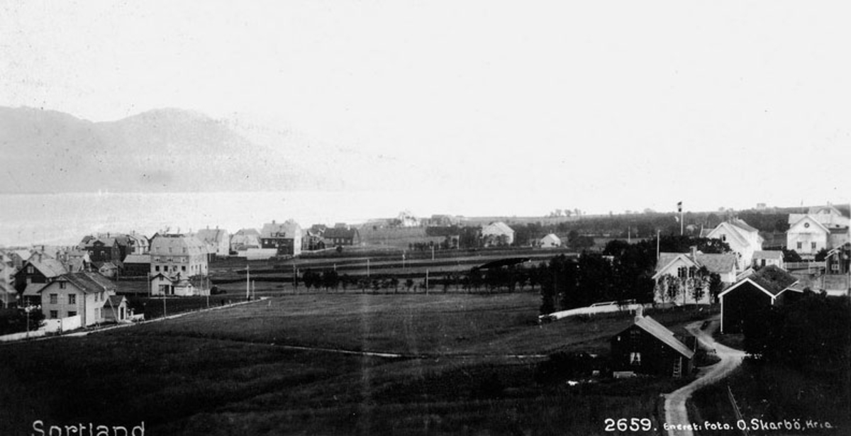 Sortland tettsted omkring 1930. I forgrunnen til venstre telegrafbygninga, til høyre Berntsen-huset, bak det hovedgården til Ellingsen-familien. Midt i bildet åpne marker med hesjer.