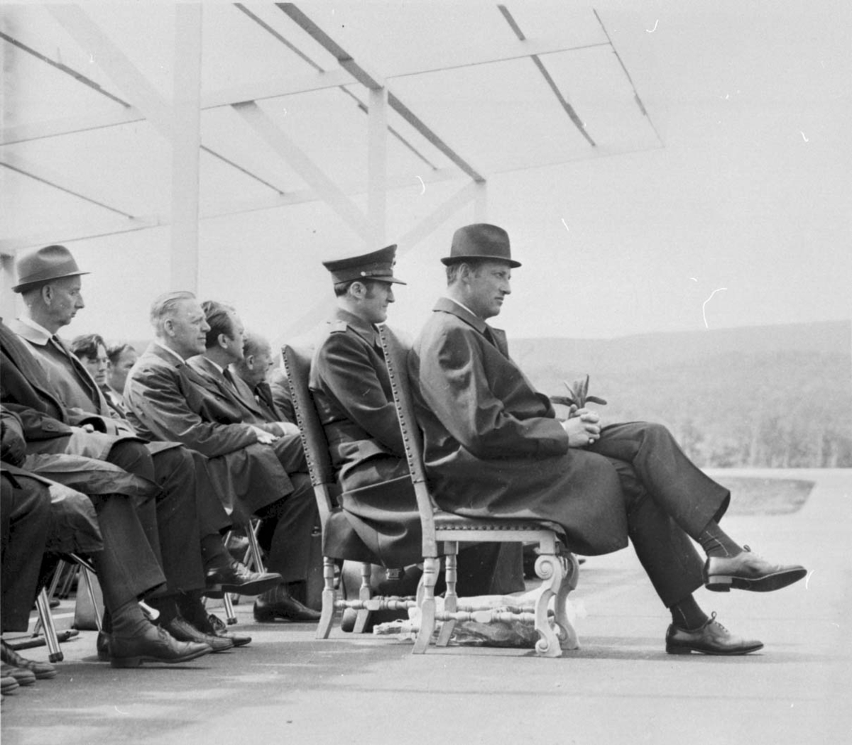 Lufthavn Gruppebilde, blant annet H.K.H Kronprins Harald sitter på stoler utendørs.