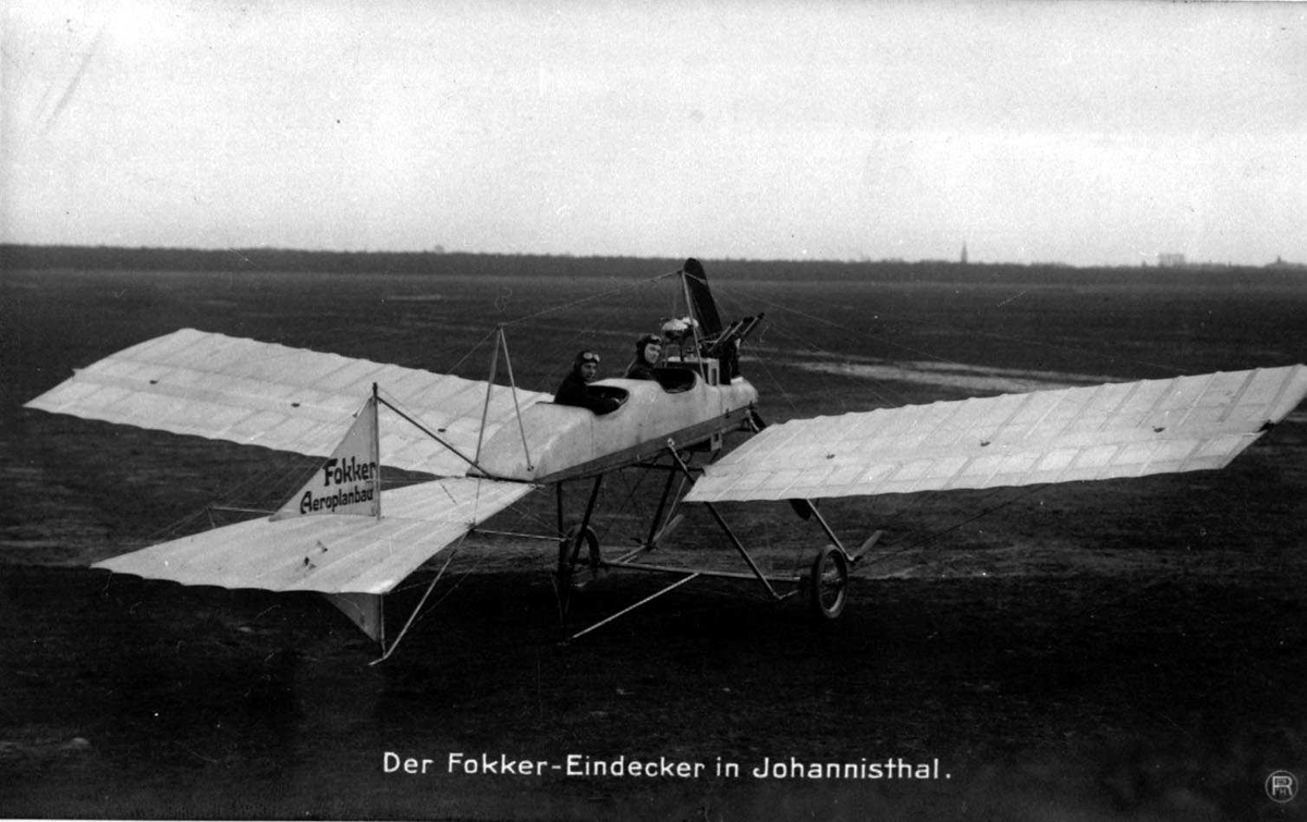 Ett fly på bakken, Fokker. To personer, menn, i flyet.