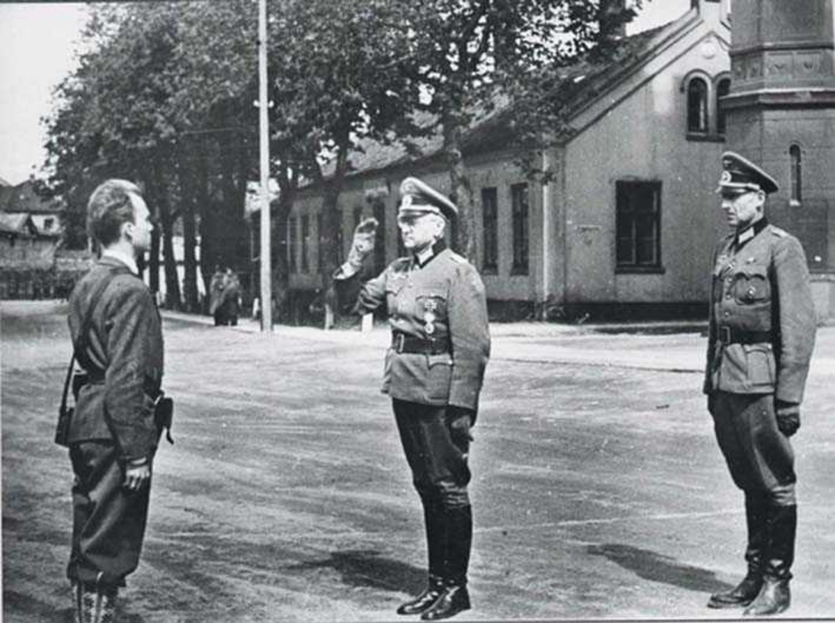 Tre menn i militæruniform. To tyske offiserer og en soldat fra hjemmefronten.