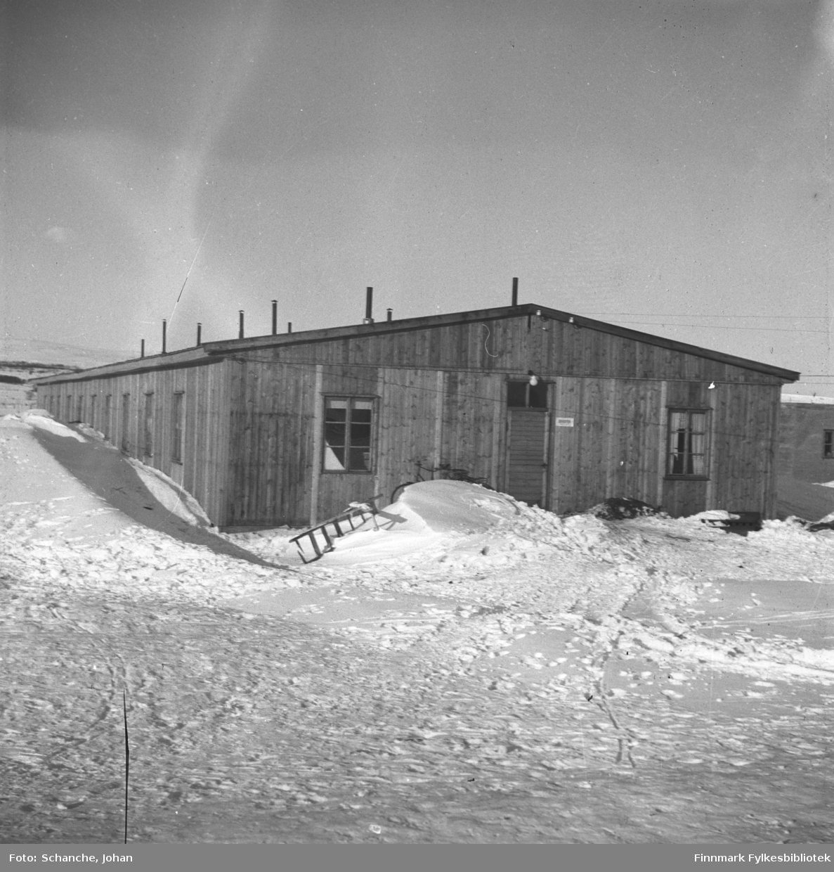 Den gamle politibrakken / sørenskriverkontor (-46-48) i Vadsø fotografert på vinter -46. Skilt på veggen med tekst:'sorenskriveren'.
