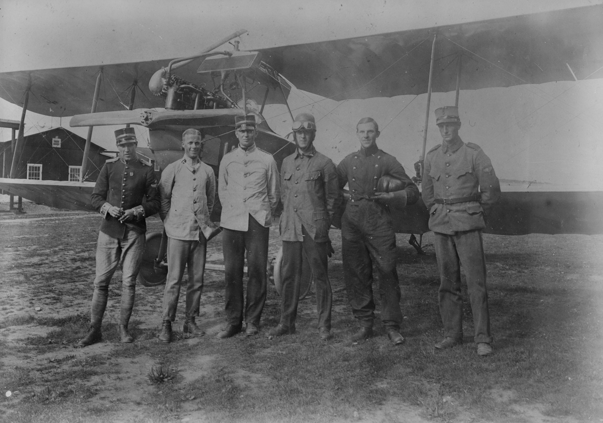 Grupporträtt. Sex stycken militärer framför flygplan Albatros B IIa. Från vänster: Paul af Uhr, Fredrik Adilz, löjtnant Högberg, Georg Gärdin, löjtnant Lilliehöök och James Dickson.