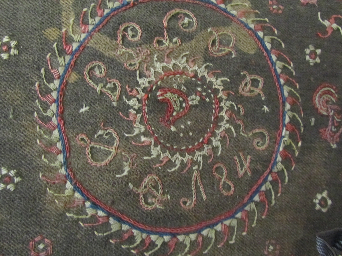 Blomar, fuglar, sirklar (solhjul), sirkulært midtfelt med årstalet 1845 og initala I G J D (truleg), akantusranke langs kanten.