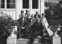 Syv personer på trappen utenfor stort hus. Juni 1936