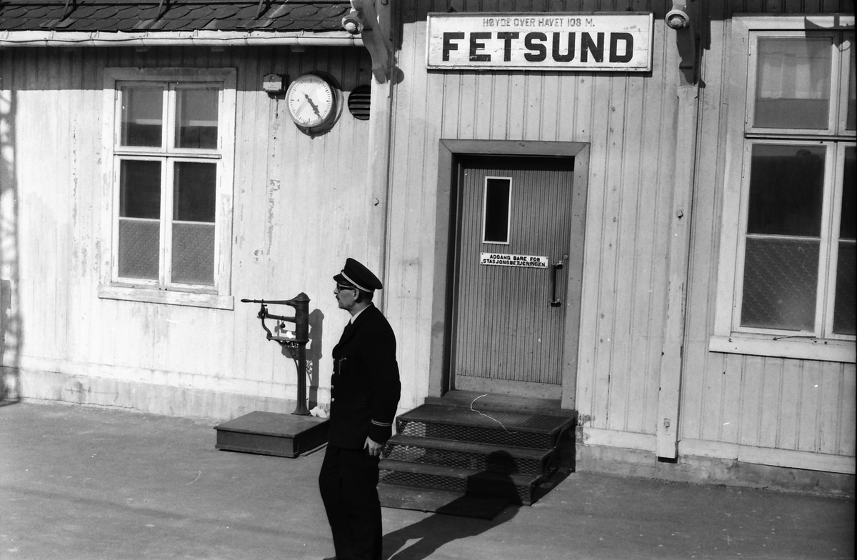 Togfører i et persontog Charlottenberg  - Oslo Ø på Kongsvingerbanen på plattformen på Fetsund stasjon, venter på å gi avgangssignal til lokomotivføreren.