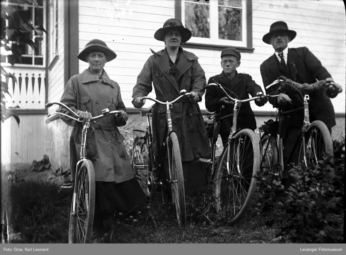 Gruppebilde, familie med sykkel, kan være tatt på losjelokalet på Øvre.