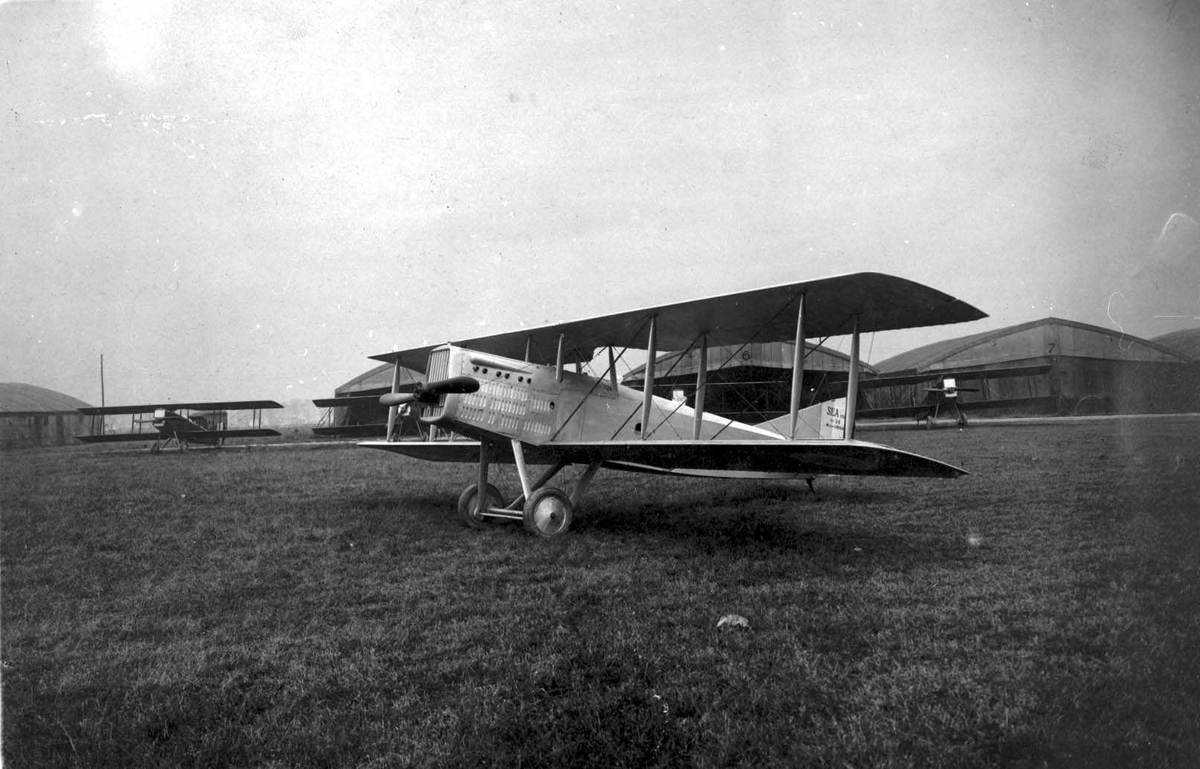 Fem fly på bakken, S.E.A. VIII (Potez). Hangarer bak.