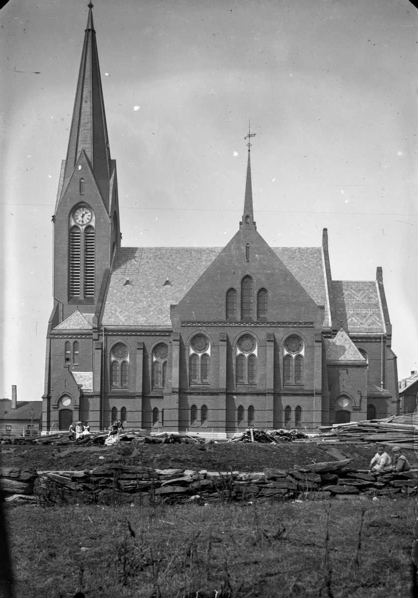 Vår Frelsers kirke sett fra sør. To gutter sitter på et steingjerde ...