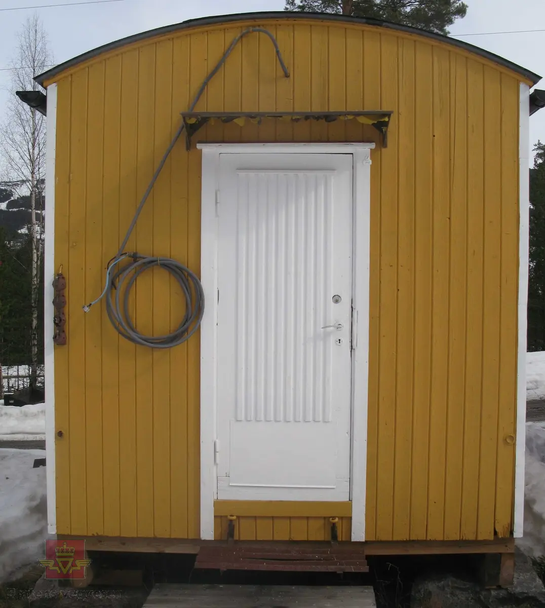 Gul hvilebrakke i tre, med et vindu i ene gavelveggen, ei dør i andre gavelveggen og to vinduer i den ene langveggen. Dør og vinduskarmer i hvitt. Stående panel, hjørner har metallbeslag. Stigtrinn under døra, skjerm over døra. Takrenner i stål, (av nyere dato, montert ved NVM)l. Buet tak kledd med papp. Elektrisk anlegg med kontakter. 2 reflekser på den ene gavelveggen. Pipe med pipehatt. Innredet med ovn, bord, skap og 2 senger med madrasser etc. Kopi av målerkort fra Vest-Oppland Kommunale Kraftselskap.