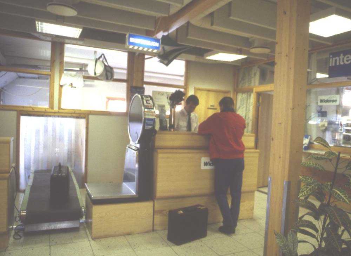 Lufthavn/Flyplass. Røssvold/Mo i Rana. En passasjer sjekker sin billett for reise med et Widerøefly.





