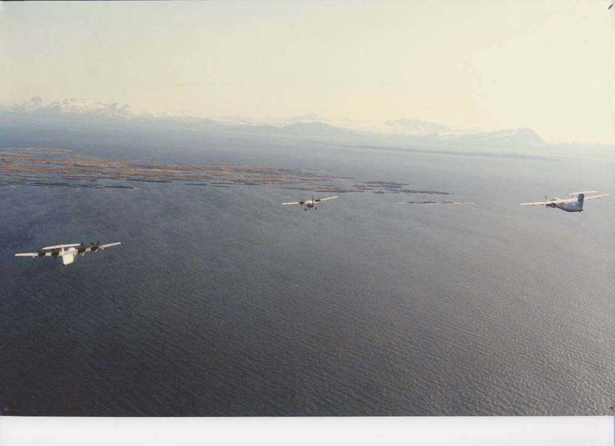 Luftfoto. Tre fly, LN-WFI, DHC7 / Dash7, LN-BNJ, DHC-6 Twin Otter og til høyre en DHC-8 /Dash8 fra Widerøe, fotografert utenfor Bodø i forbindelse med åpningen av Norsk Luftfartsmuseum Bodø. Skagodden i forgrunnen og Børvasstindene med Sandhornet til høyre.