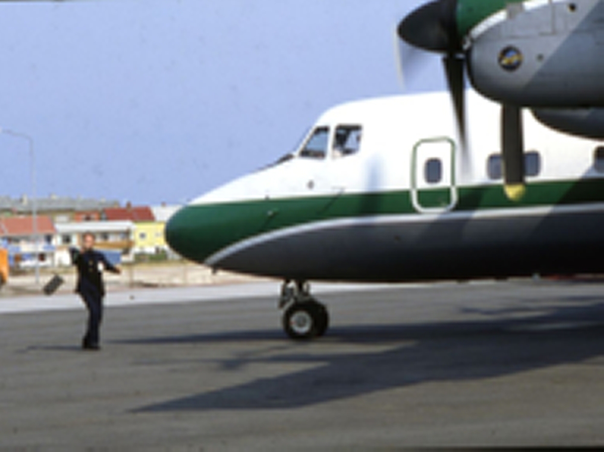 Lufthavn (flyplass). Et fly, DHC-7-102 Dash 7 fra Widerøe parkert. En person foran flyet.