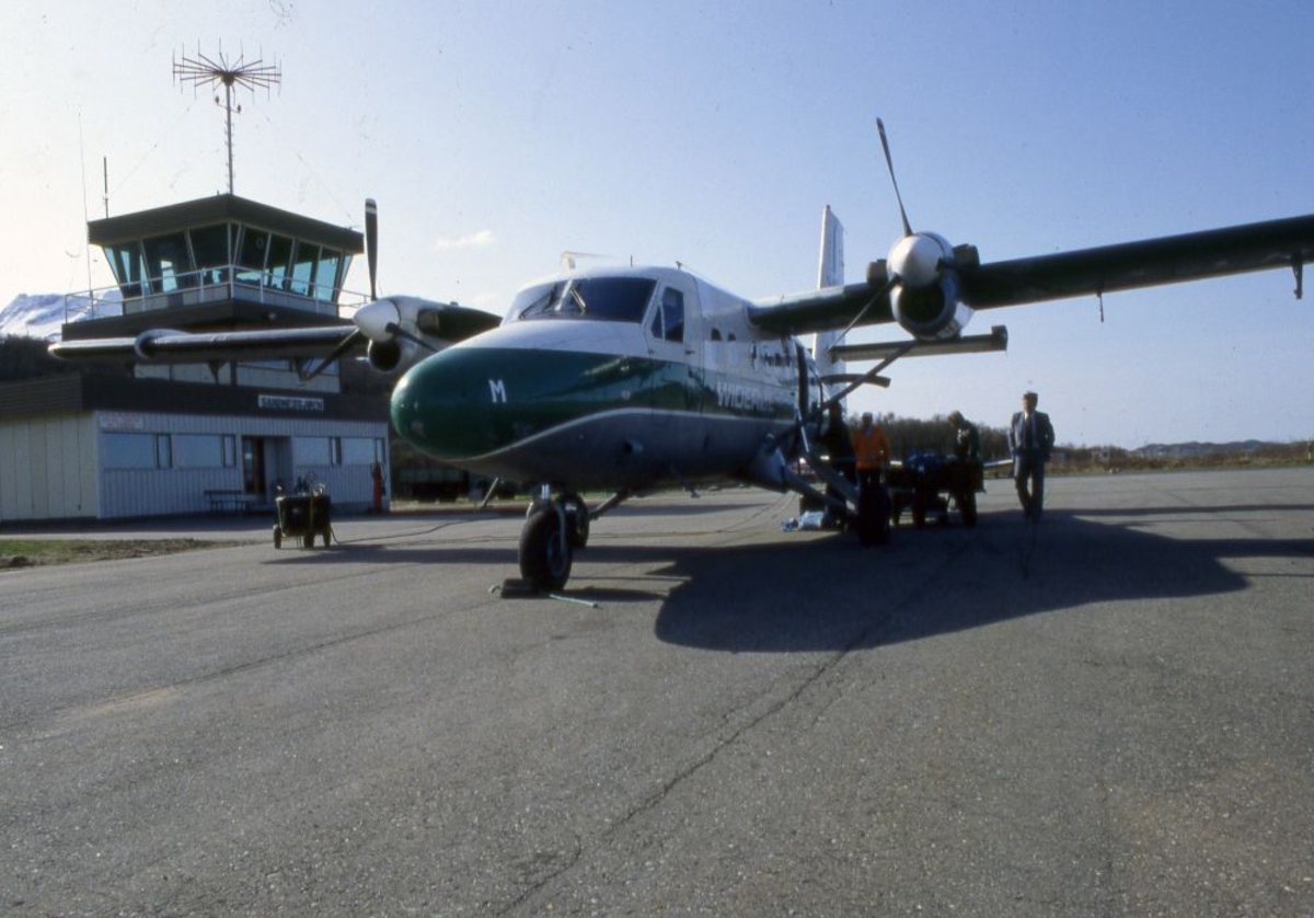 Lufthavn (flyplass). Et fly, LN-BNM, DHC-6-300 Twin Otter fra Widerøe. Flere personer i aktivitet.