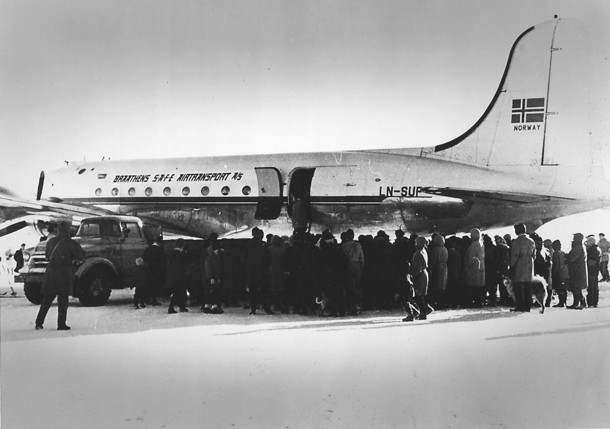 Lufthavn (flyplass). Ett fly på bakken, Douglas C-54 Skymaster, LN-SUP "Norse Commander" fra Braathens Safe. Mange personer og ett kjøretøy ved flyet. Snø på bakken