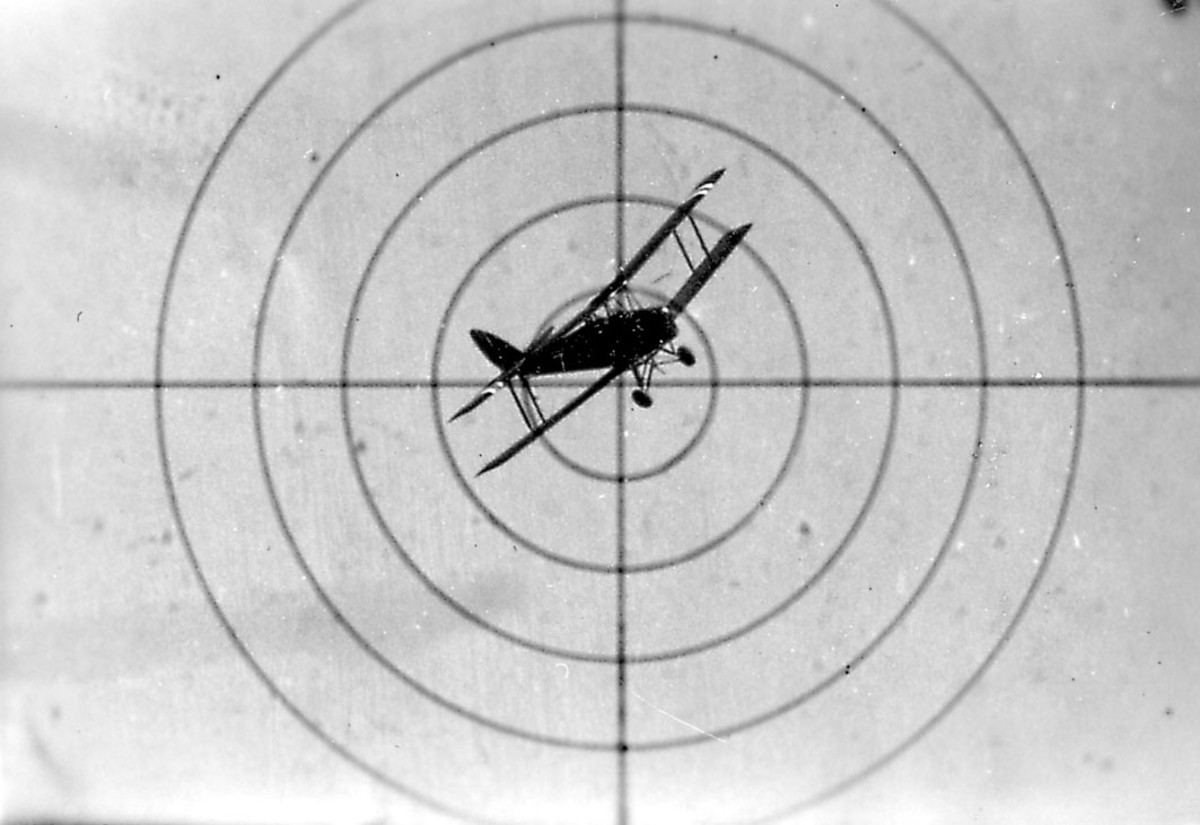 Luftfoto, ett fly i luften, sett gjennom våpensikte.
Tiger moth i sikte: