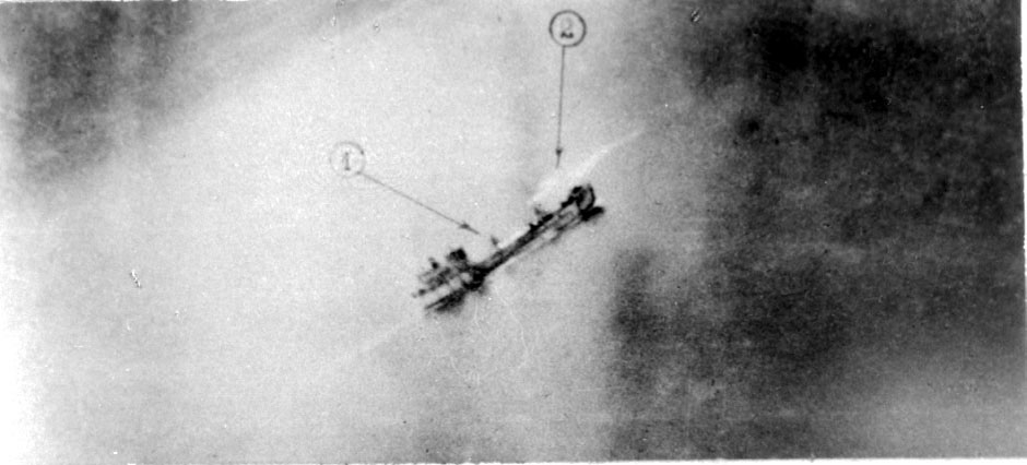 Luftfoto. Nedenfor sees et fartøy på åpent hav i fart. 2 posisjoner er merket av på bildet for hånd.