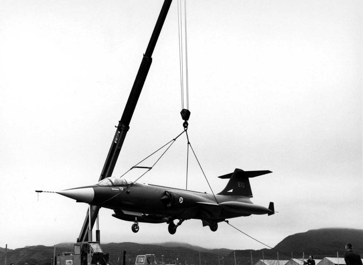 En CF-104 henger i en heisekran.