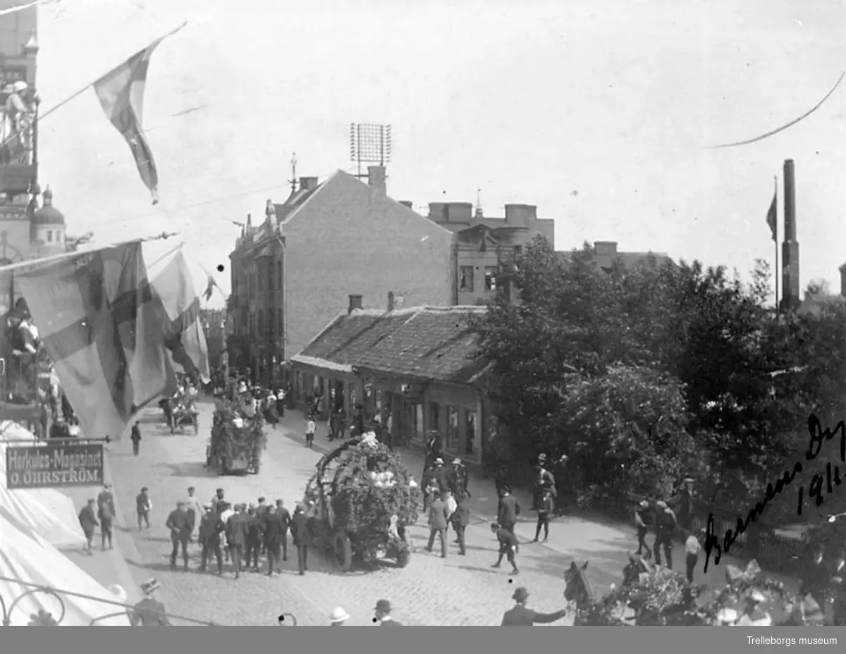 Barnens dag 1911. Festtåget passerar Algatan. Rådhuset ligger bakom muren till höger i bild.