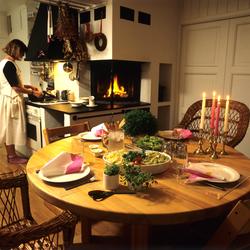 Kjøkken med peis. Dekket middagsbord hvor det serveres pasta