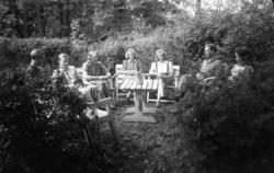 En gruppe mennesker fotografert i en hage