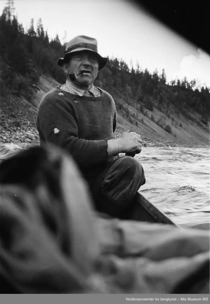 Henry Tangen sitter i elvebåten, med en pipe i munnen.
Bildet er tatt i fiskesesongen på sommeren i 1949.