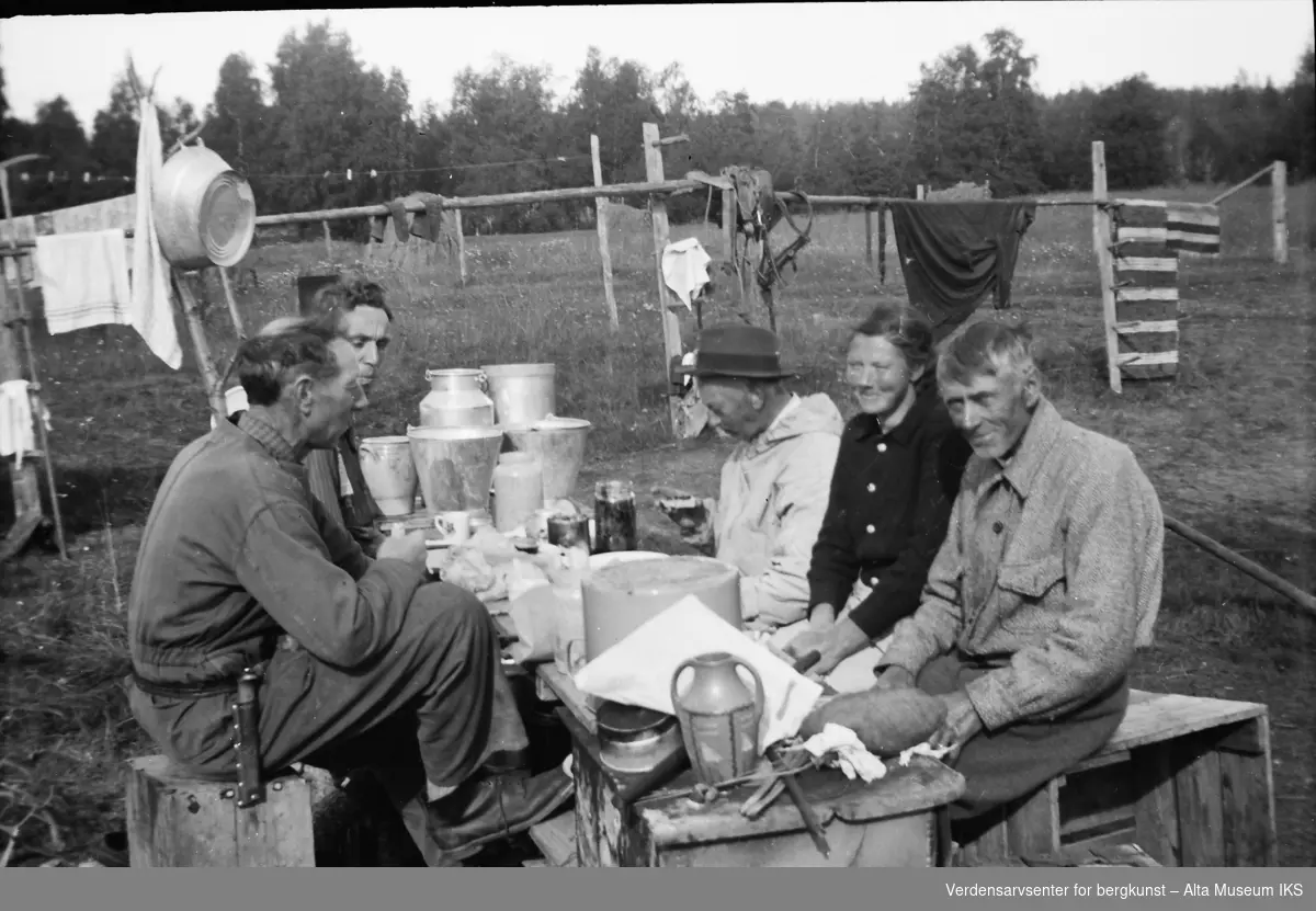 Ole Roald Jøraholmen (Nærmest til venstre) sitter ved et improvisert bord med fire andre. De sitter på kasser.