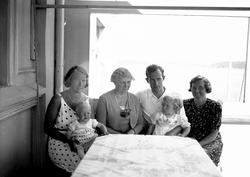 Tre kvinner, en mann og to barn på Lyng Olsens veranda. Krag