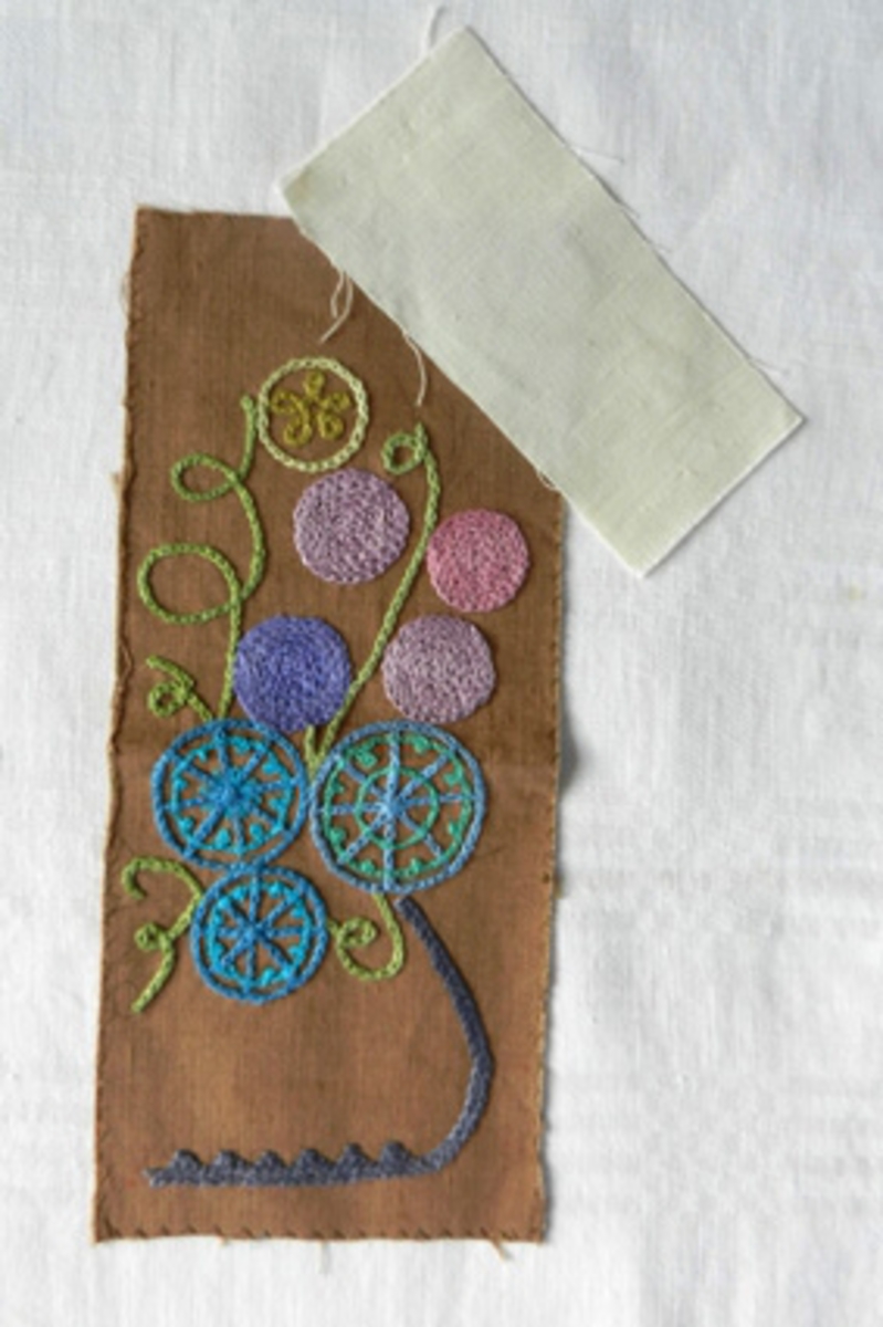 Bonad/broderad tavla. Modellnamn "Sofi". Mönstret komponerat av Anna Hådell 1977.
WLHF 995:1 - Tavla i brunt linnetyg med broderi i kulört lingarn utfört i kedjesöm. Mönster i form av en blomsterurna i blått med stiliserade blommor i blå, ljusgröna och rosa nyanser. Broderiet är fäst på en spännram med lim och häftklammer.
WLHF 995:2 - Provlapp. Brunt bottentyg i lin med påbörjat broderi i gråblått, blått, turkos, grönt och rosalila. Mått 115x270 mm.