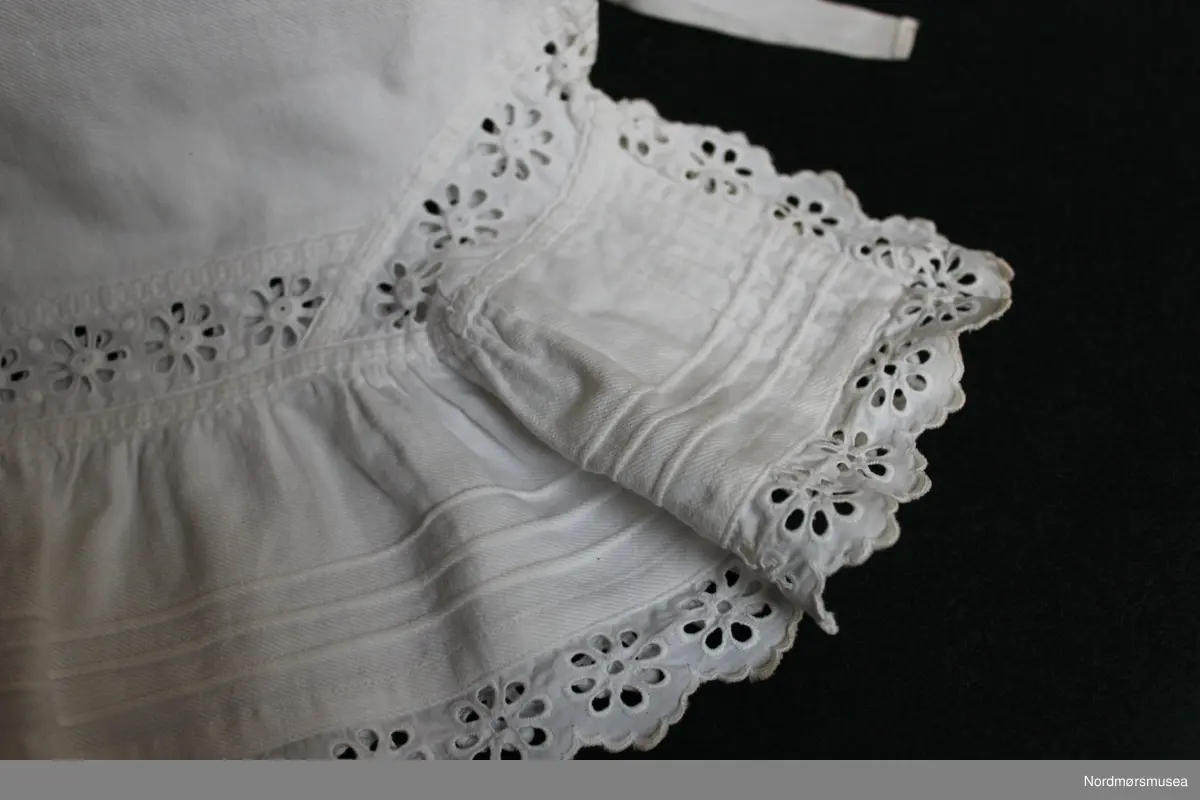 Knelang underbukse for dame. Maskinsøm i bomull. Knyting i begge sider i livet. Blonder i avslutning ved kneet.