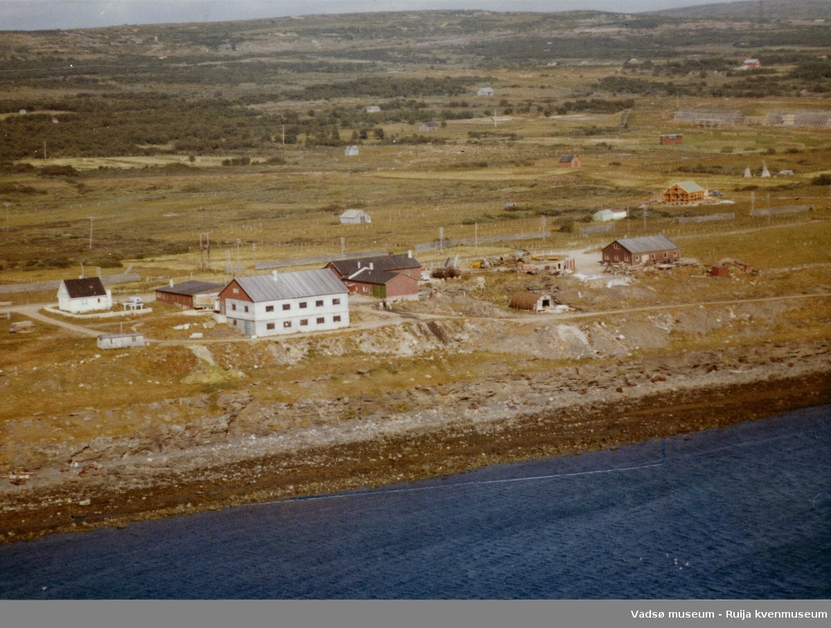 Flyfoto av Vadsø, Veisletta som er vest for byen, 1963. Statens veivesens bygninger er midt i bildet.