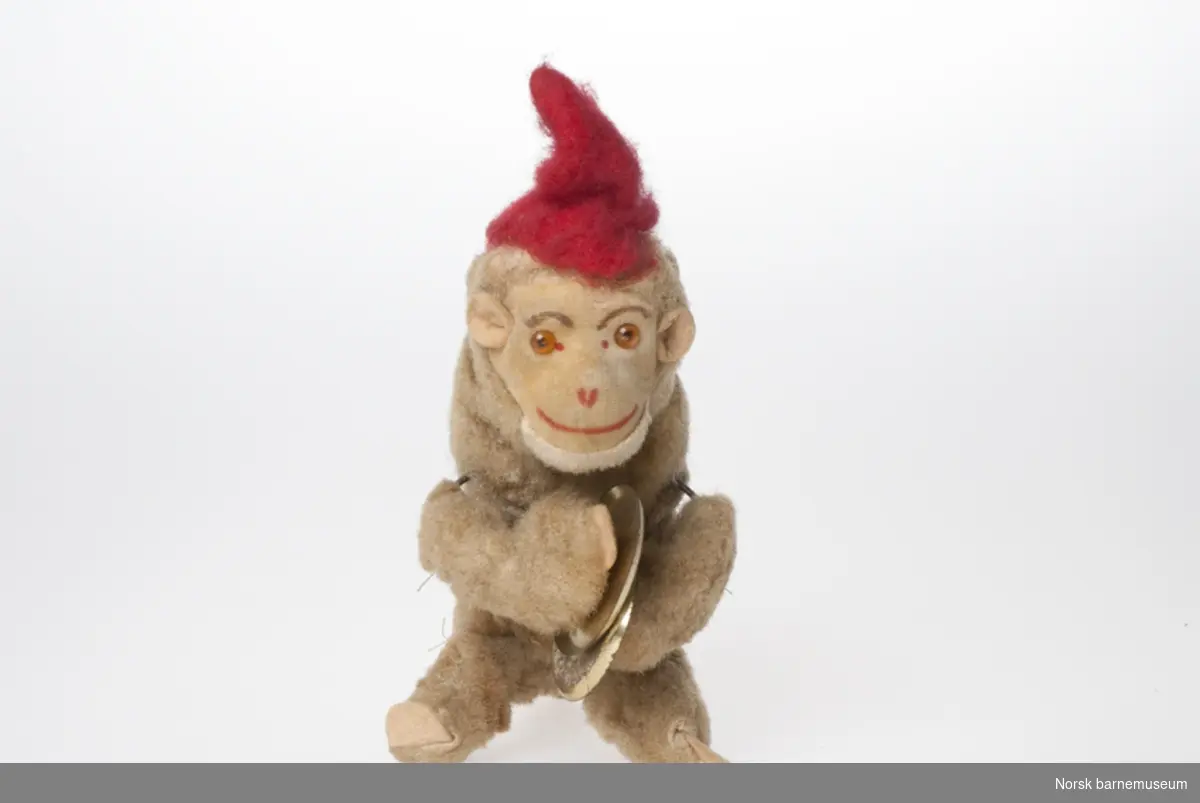 Ape med cymbaler: En opptrekkbar ape, med rød spisshatt og tromme.