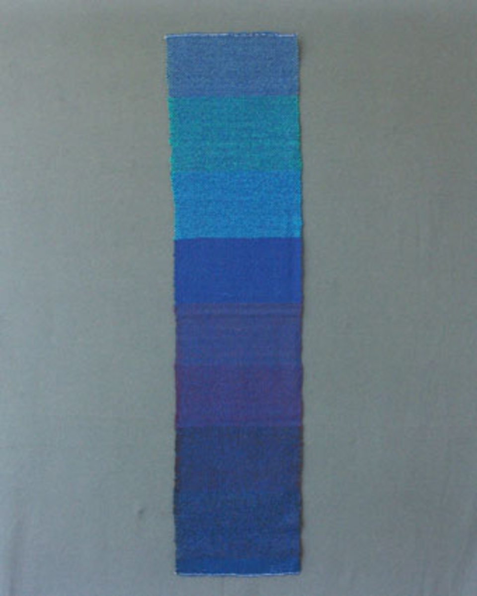 Prov till scarves vävd i tuskaft med blått ullgarn i varp och grått, brunt, lila, blått, blågrönt och grönt ullgarn i inslag.