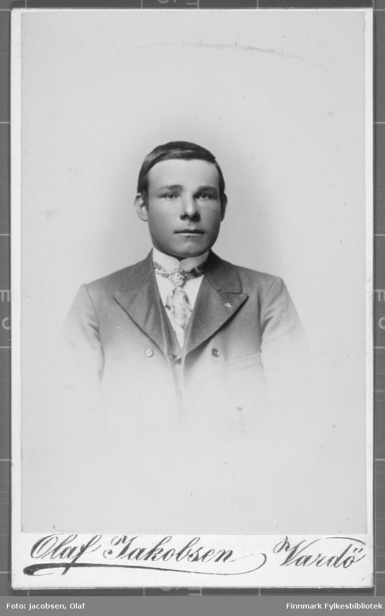 Portrett av en ung mann jakke slips hvit skjorte studio ateliere hvit bakgrunn.   Albumet med bildet kommer fra Ekkerøy, kanskje han kommer derfra.