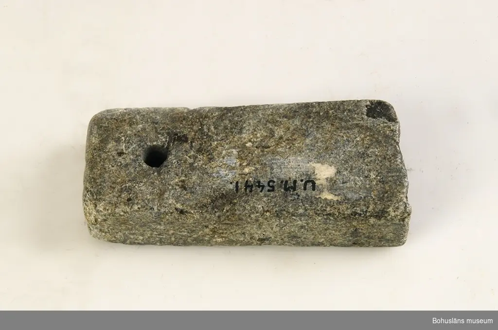 Ur handskrivna katalogen 1957-1958:
Gjutform, sten för knappar
Mått: 10 x 4,2 x 1,2 cm; Täljsten; en del av formen avbruten.

Lappkatalog: 33
