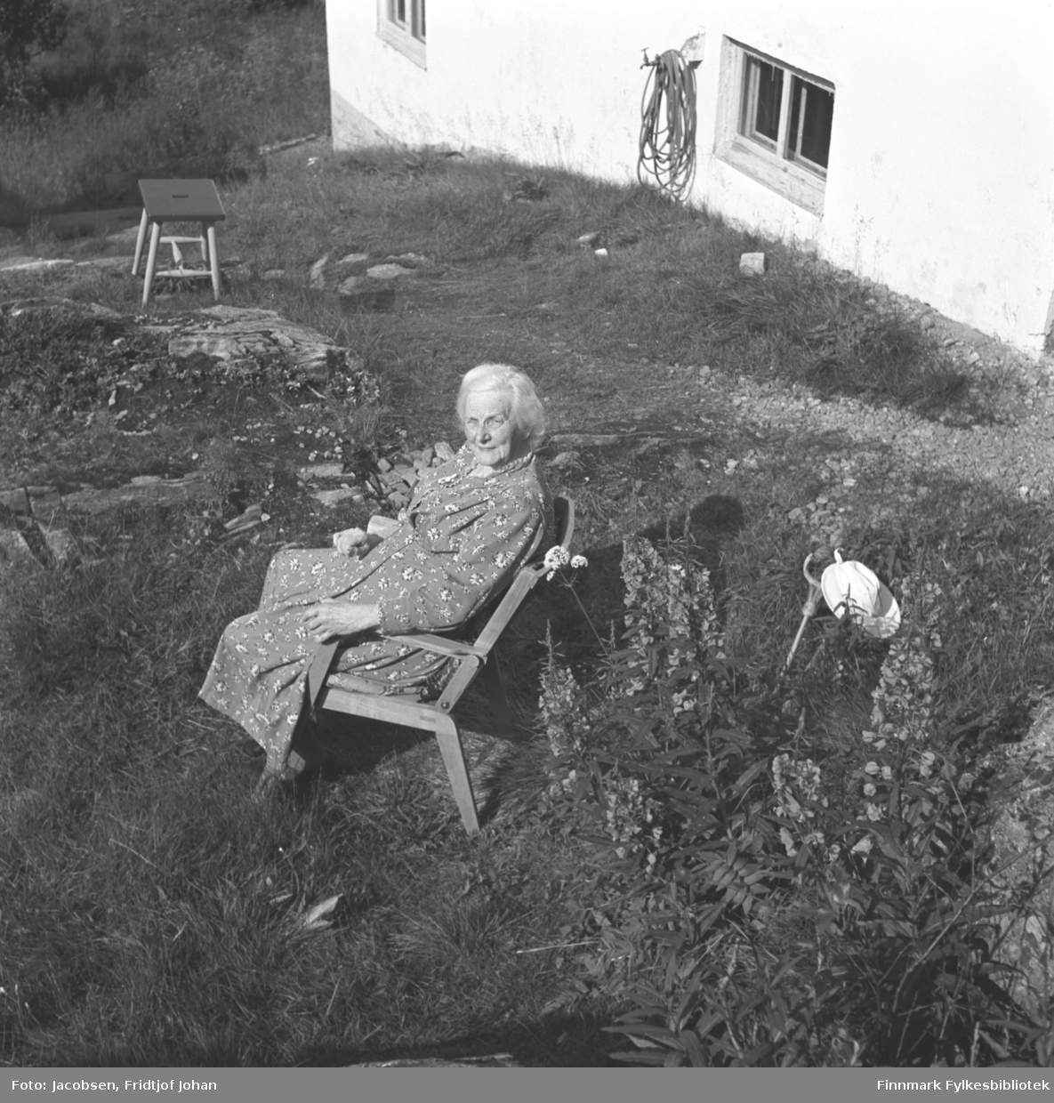 Olga Jacobsen soler seg i hagen utenfor Arne Nakkens hus i Rypefjord.