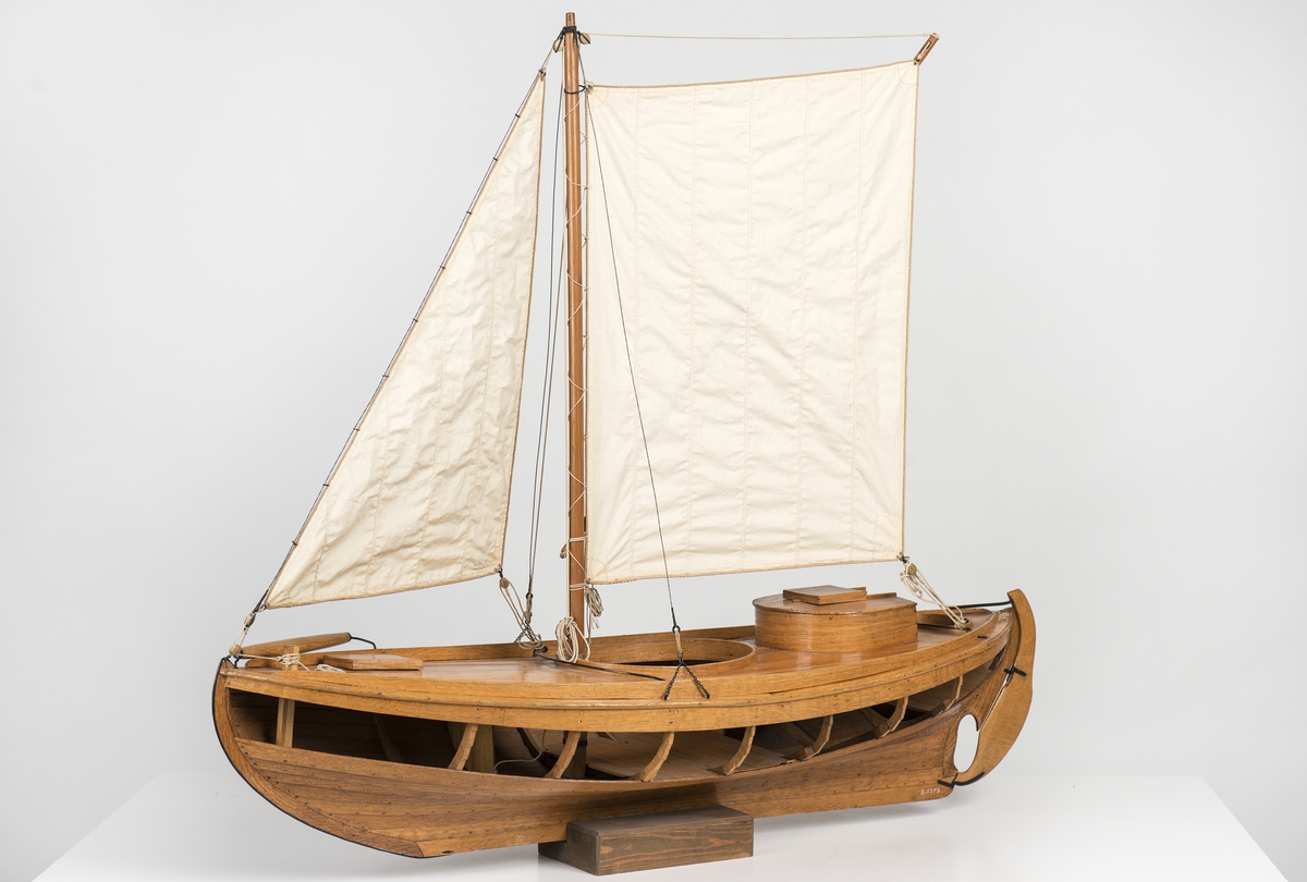 Modell av den för Öresund typiska sillfiskebåten Öresundskostern. Byggd på klink av ek, riggad, däckad fiskebåt. På styrbords bog rulle för dragningen av sillgarn. Akterut rund kapp med nedgångslucka till maskinrum. Reducerad rigg med låg mast, stagfock och sprisegel. Fartyget konstruerades av båtbyggaren A. R. Gustafsson i Landskrona, som även byggde modellen. Den korta kölen, fylliga övervattenskroppen och S-formade akterstäven är karaktäristiska drag för den senarste årtiondenas fiskefartyg. Babords sida öppen, rullbom på styrbords bog. Rund lastlucka och ruff över motorrummet. Kort mast i koger, med sprisegel och fock. Fyra lösa durkar, motor och propeller saknas. Skala 1:12.
Skrå saknas.