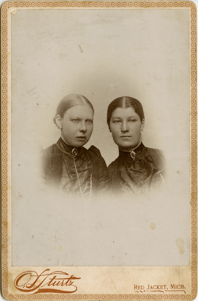 Halvfigursportrett av to unge kvinner, Hilda Niva og Selma Methi. Damene er kvener fra Vadsø som emigrerte til Michigan, Usa, i 1870-årene