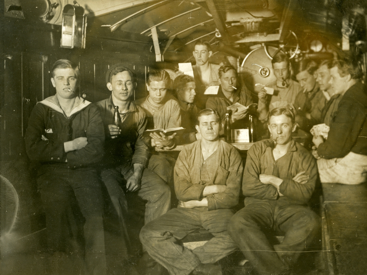 Sjömän i gruppbild ombord 1.klass torpedbåt PERSEUS. "Torpedrumsro". Femte personen från vänster i mellersta raden heter Gustaf Andersson.