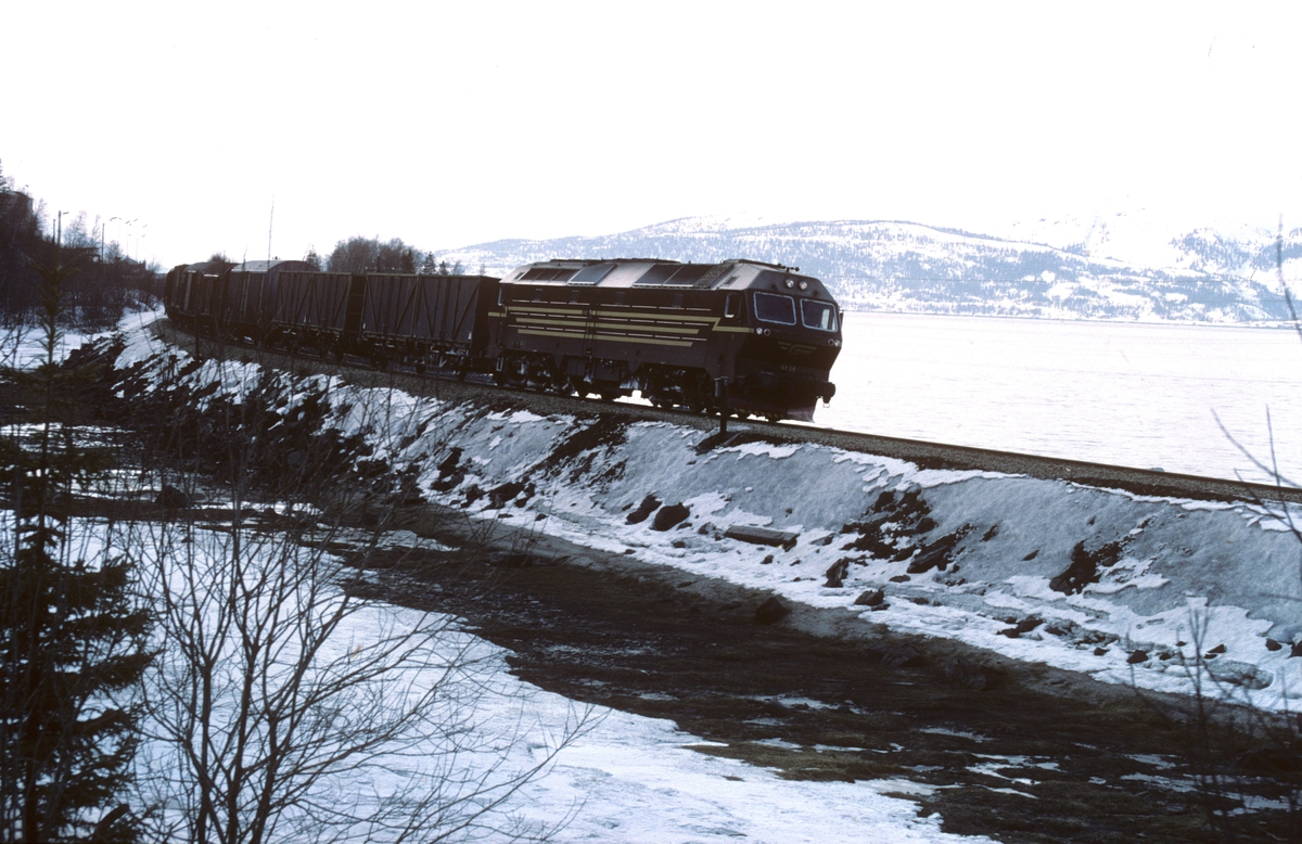 Godstog 5791 Alnabru - Bodø kjører ut fra Mo i Rana med dieselelektrisk lokomotiv Di 4 654. Dette var før det ble fylt ut masse og bygd godsterminal her.