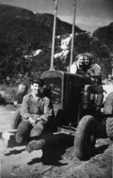 Tre personer på traktor, et barn i tilhengeren. Ostern i Tor